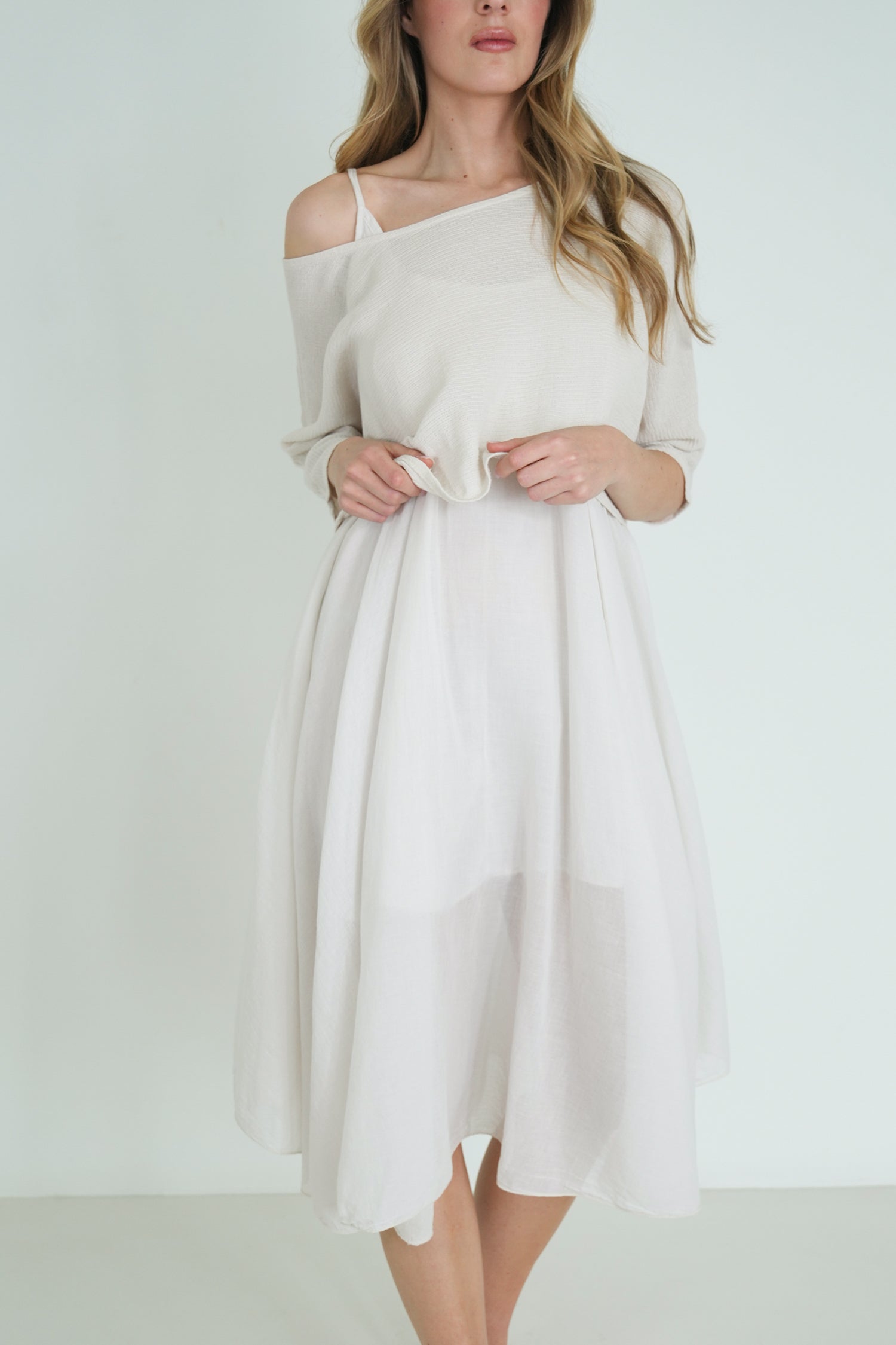 Woman wearing a white dress against a plain background
