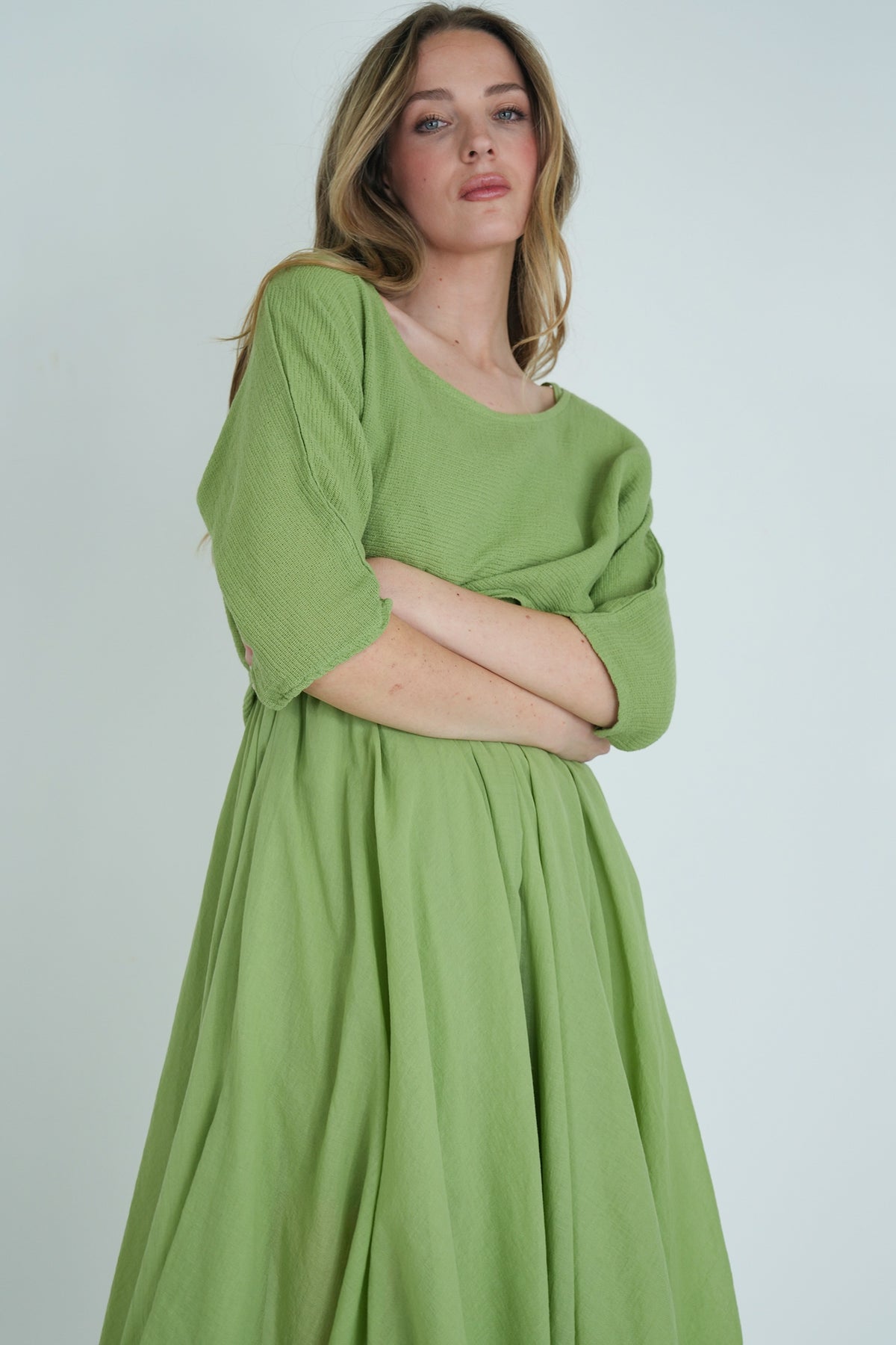 Woman wearing a green dress against a plain background