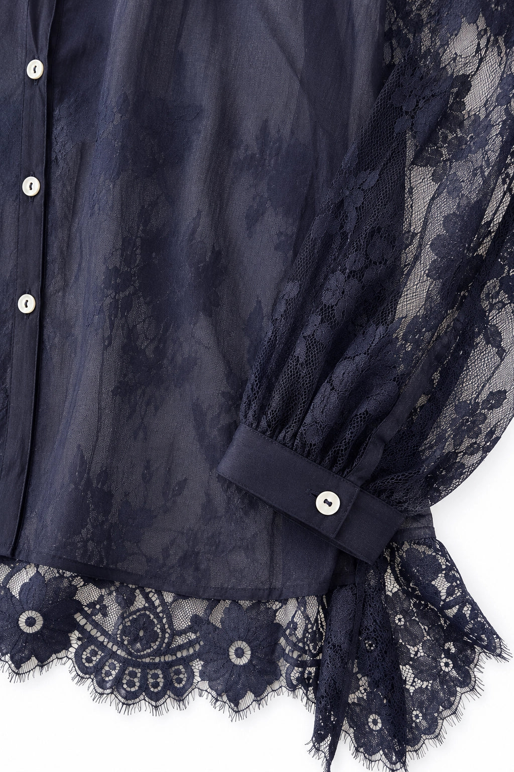 Close-up of a navy sheer mesh blouse with floral lace trim, long balloon sleeves, and a buttoned cuff.