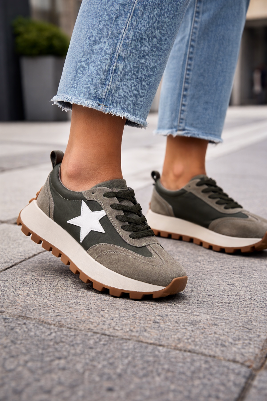 Gray sneakers with a white star on a sidewalk