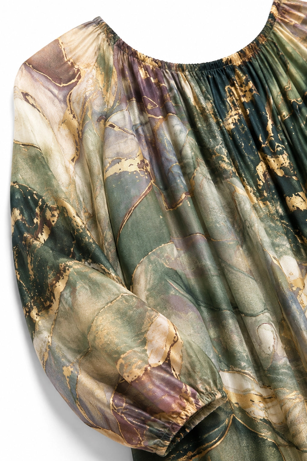 A close-up of a long-sleeve blouse with a gathered, pleated bodice and a flowing, semi-sheer fabric featuring an abstract marble pattern in muted green, beige, brown, and gold tones.