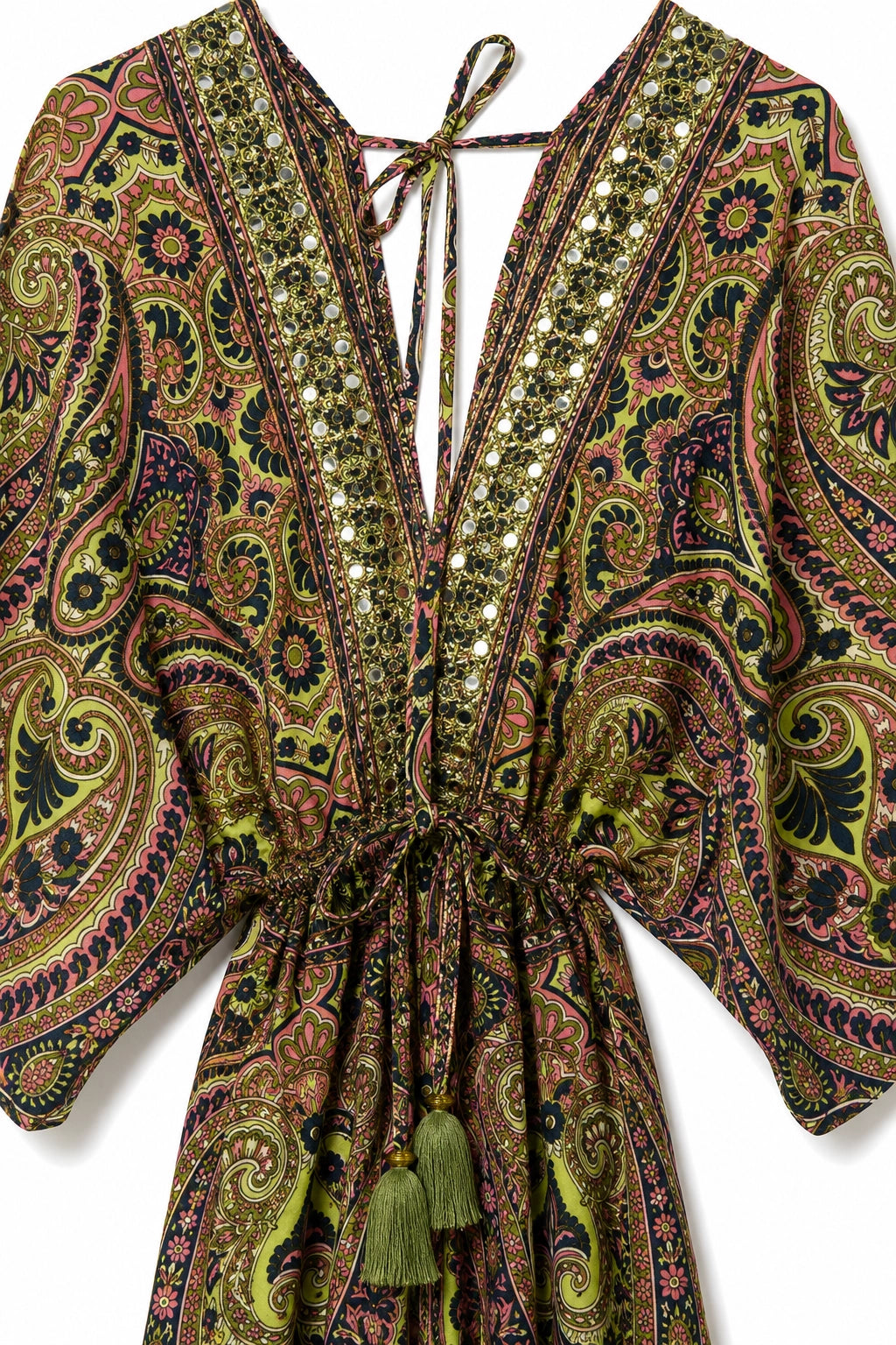 A close-up of a bohemian-style kaftan dress featuring a complex paisley and floral pattern in olive green, brown, pink, and black, embellished with sequins and tassel ties.