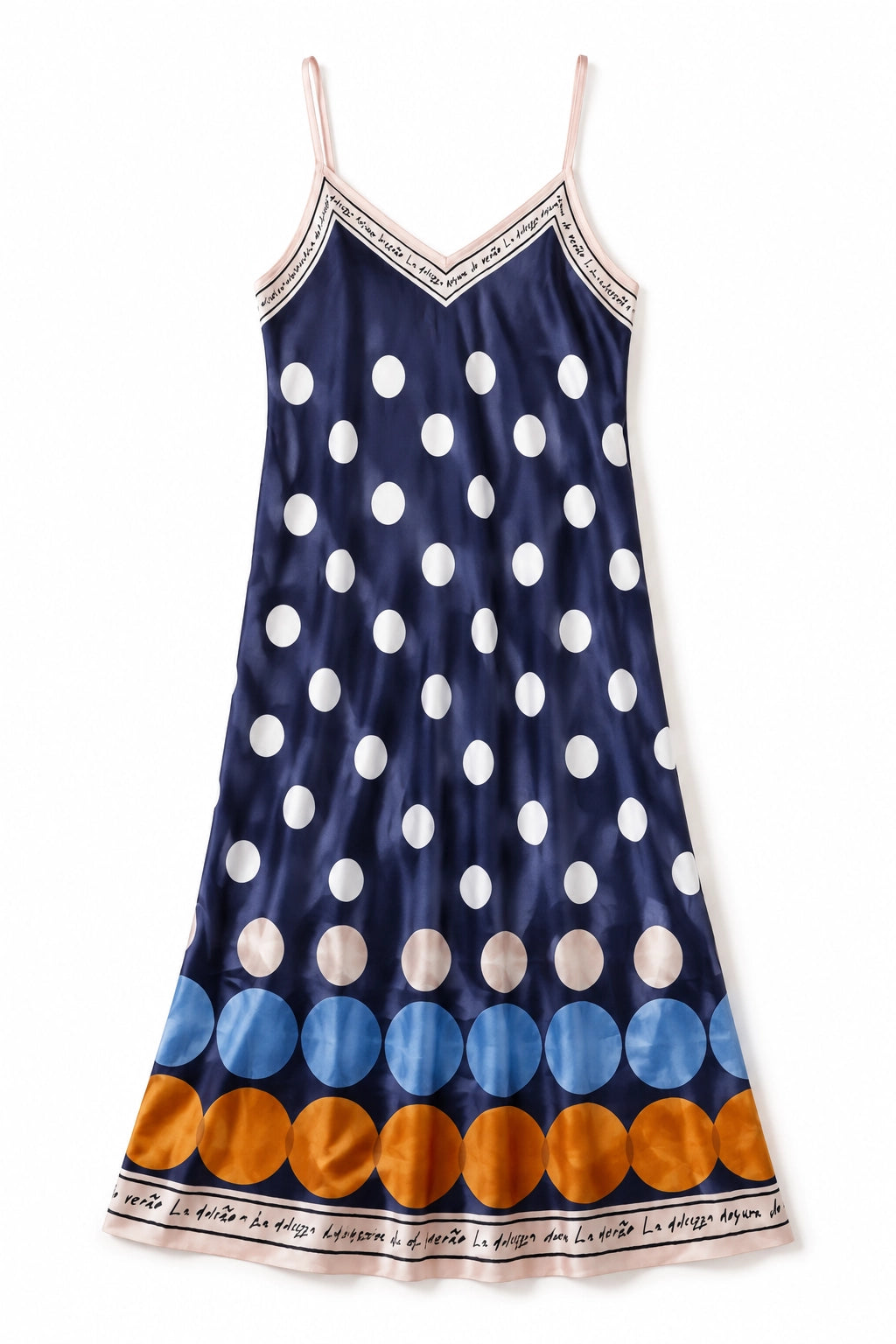 A navy blue satin slip dress with large white polka dots, a band of blue and orange polka dots near the hem, and a patterned border trim.