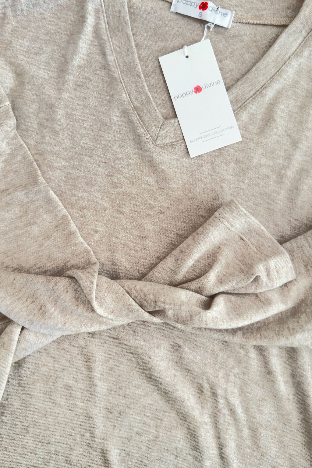 Beige t-shirt with a tag on a beige background