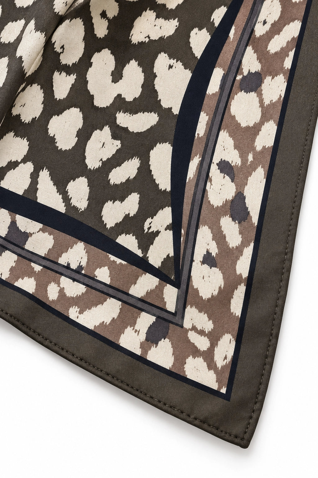 A close-up of a square scarf with a brown and beige animal print pattern, featuring dark navy blue borders.