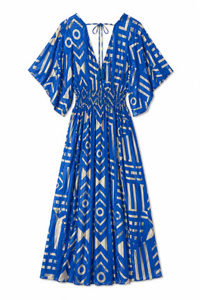 A blue and white geometric print midi dress with a smocked waist, short flutter sleeves, and a tie-neck detail, shown against a plain white background.