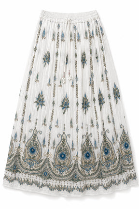 A white pleated midi skirt featuring intricate blue, gray, and gold embroidery, including vertical chain motifs and a large ornate paisley border at the bottom.