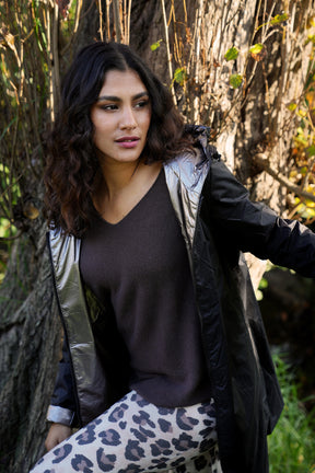 Woman standing outdoors with trees and grass in the background