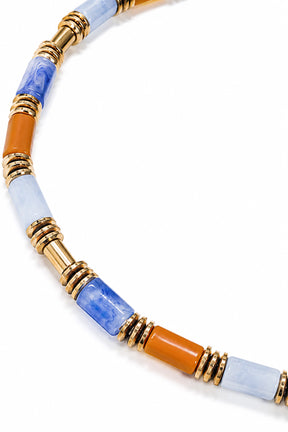 Necklace with multicolored beads and gold accents on a white background