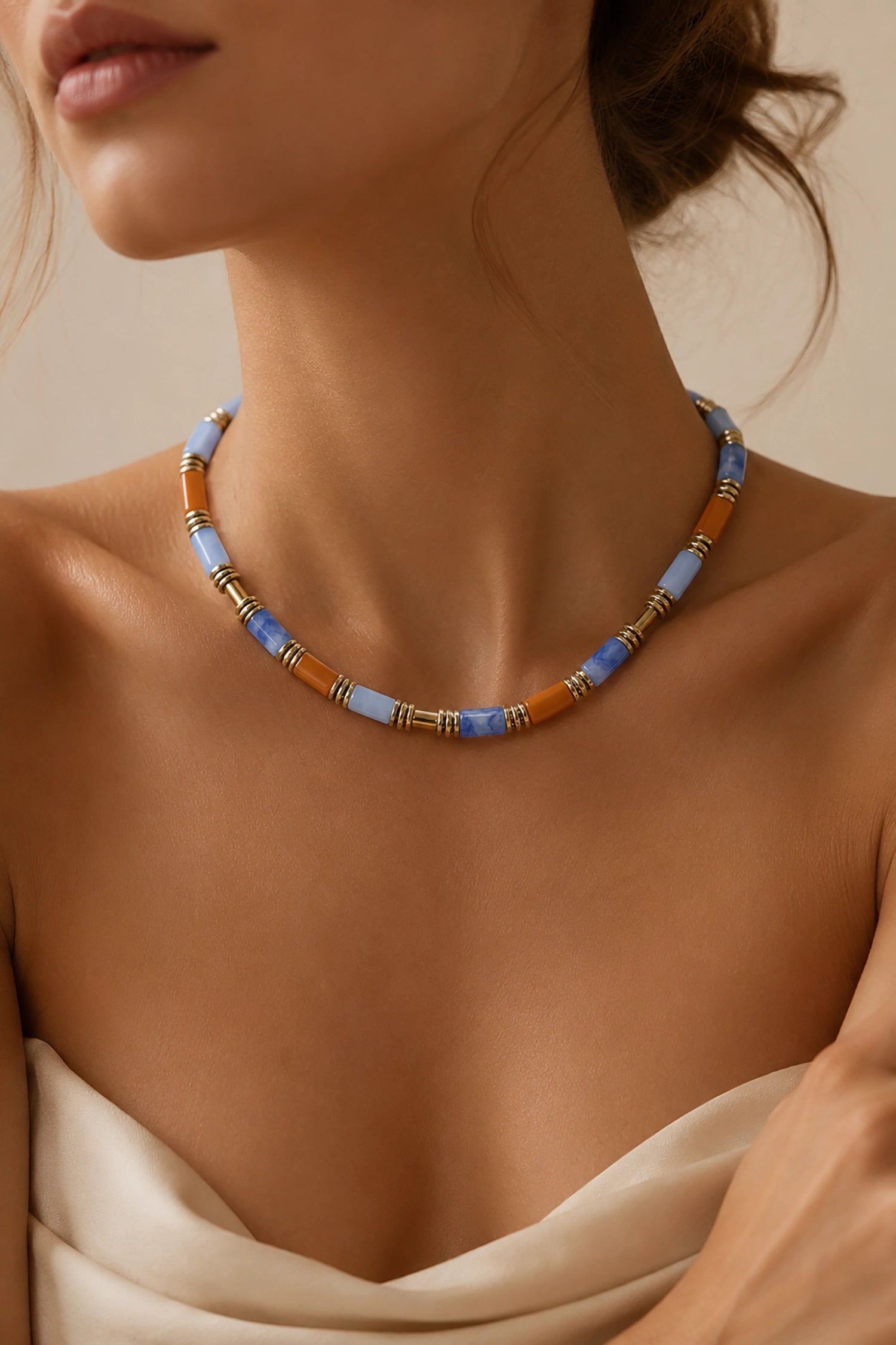 Necklace with blue and brown beads on a model against a beige background