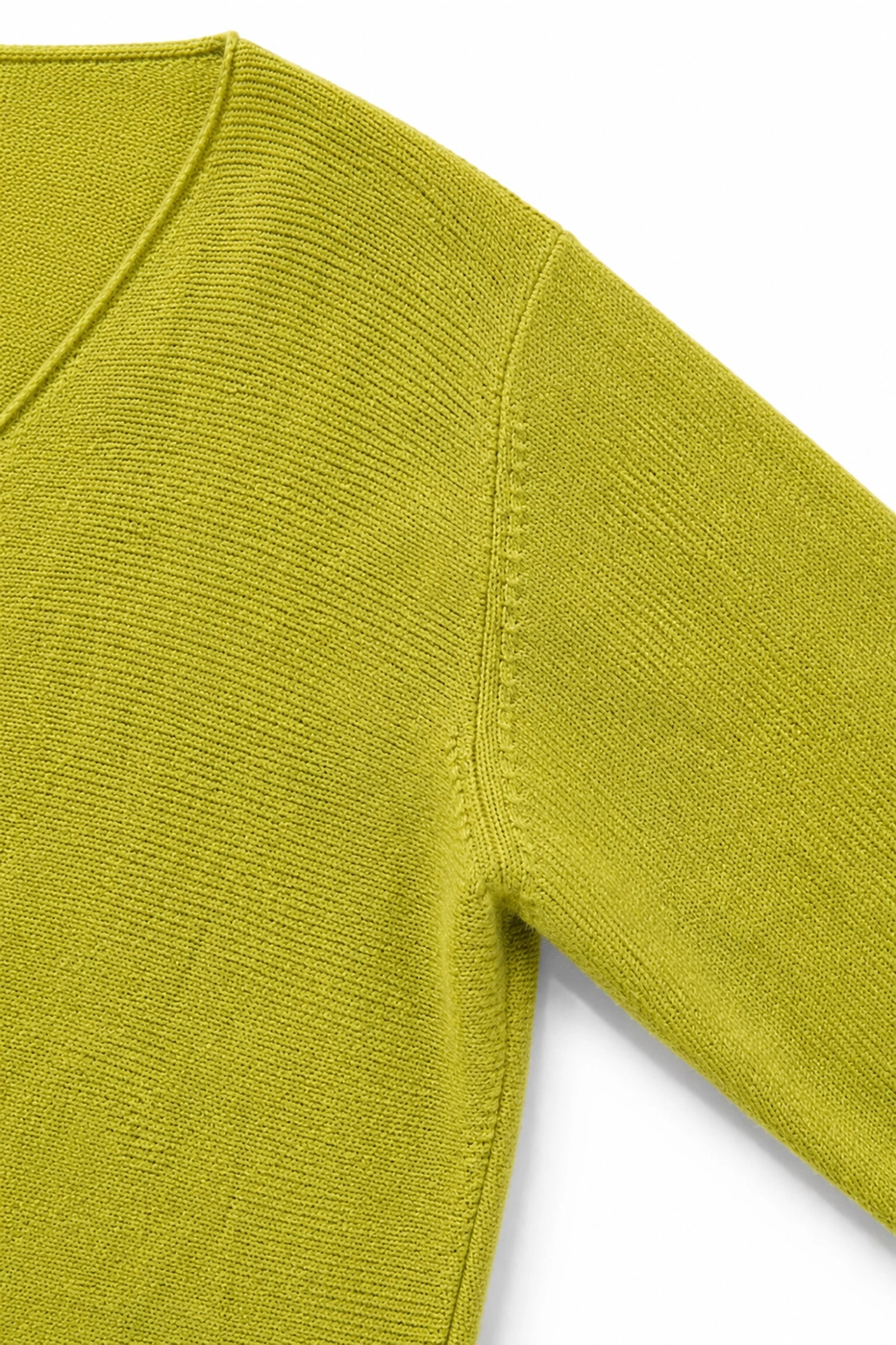 Close-up of a green sweater sleeve on a white background