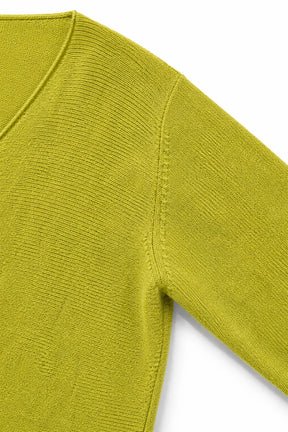 Close-up of a green sweater sleeve on a white background