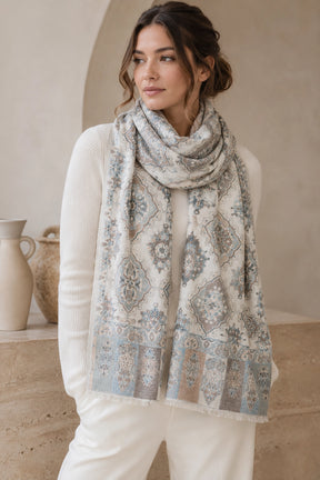 Woman wearing a patterned scarf in a neutral setting