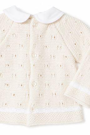 Cream-colored knitted cardigan with white collar on a white background