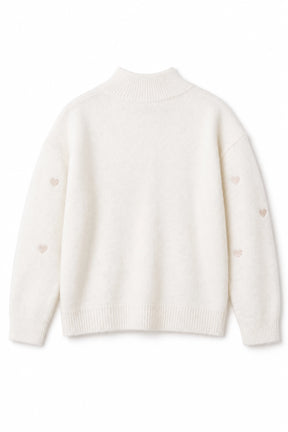 White sweater with small heart patterns on a white background