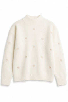 White sweater with small pink hearts on a white background