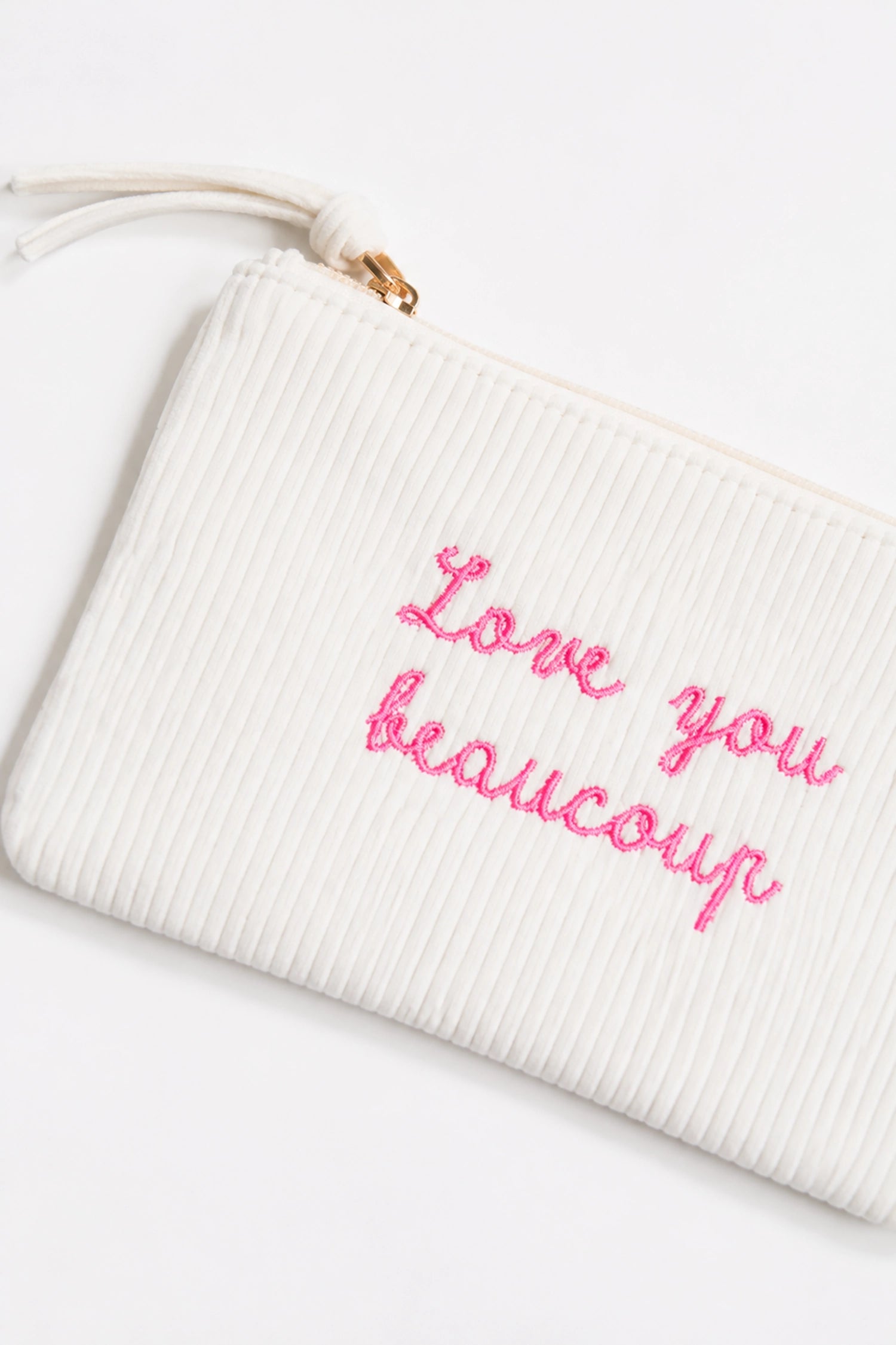 White pouch with pink text 'Love you beaucoup' on a white background