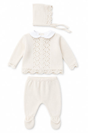 Baby outfit set with knitted top, pants, and bonnet on a white background