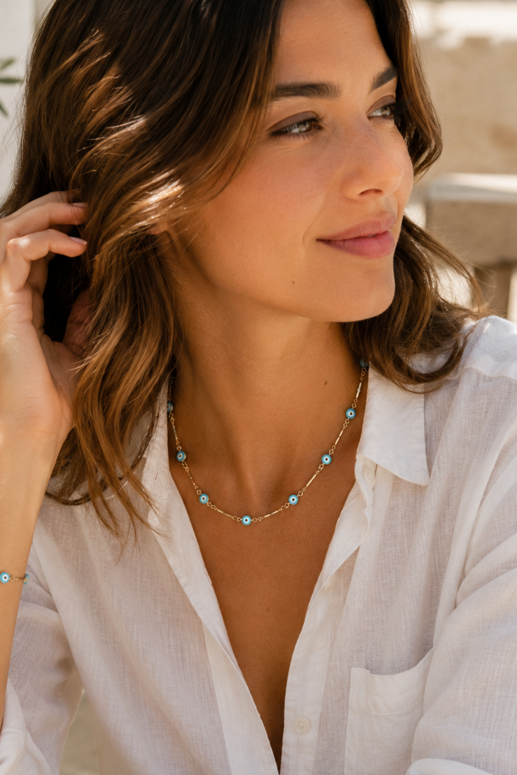Woman wearing a white shirt and a necklace with a blurred background