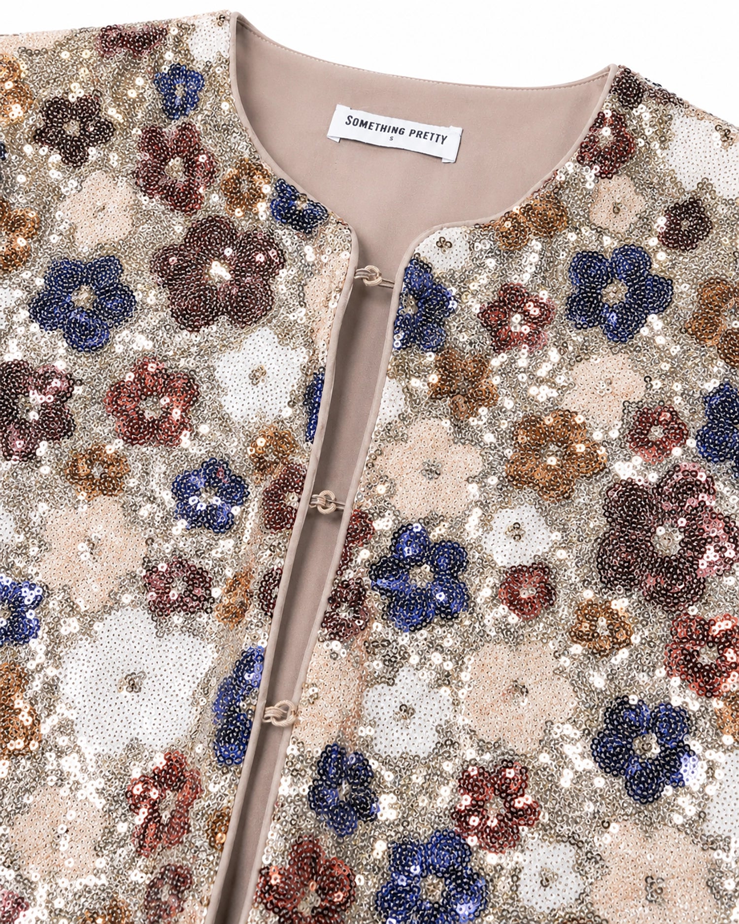 Sequined floral patterned garment with 'Something Pretty' label.