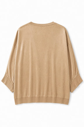 A light tan knit top with three-quarter sleeves and ribbed cuffs, shown from the back on a white background.