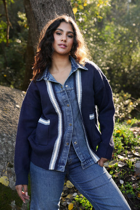 Woman wearing a blue denim jacket with white stripes outdoors
