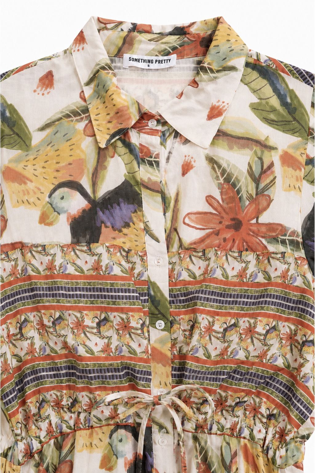 Colorful tropical patterned shirt with birds and flowers on a white background