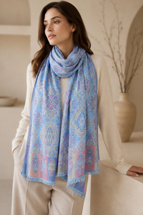 Woman wearing a blue patterned scarf in a neutral setting